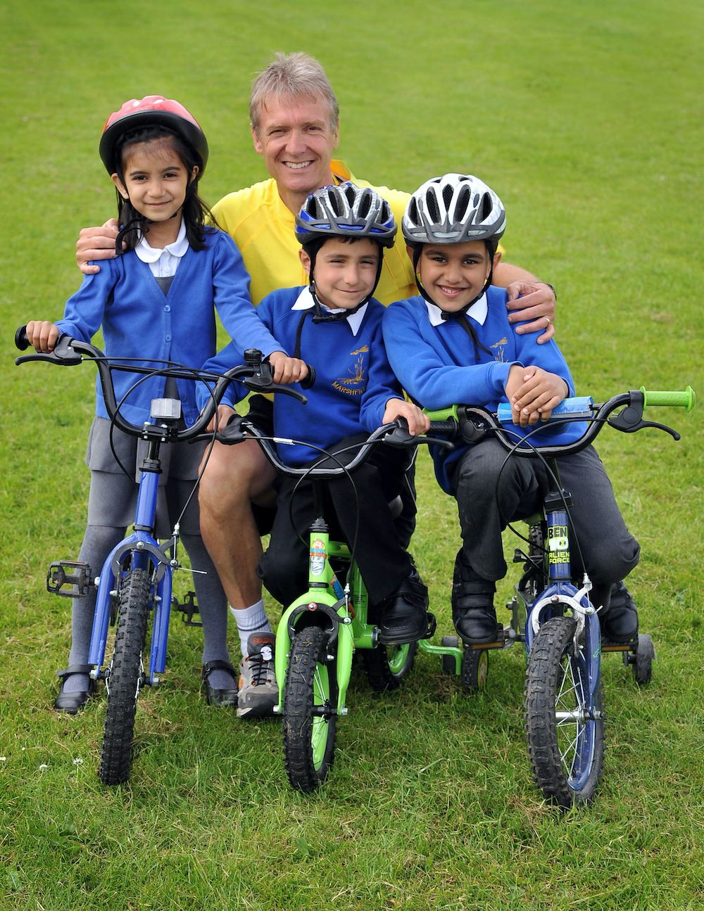 Phil Bateman with three pupils on their bikes on the school field